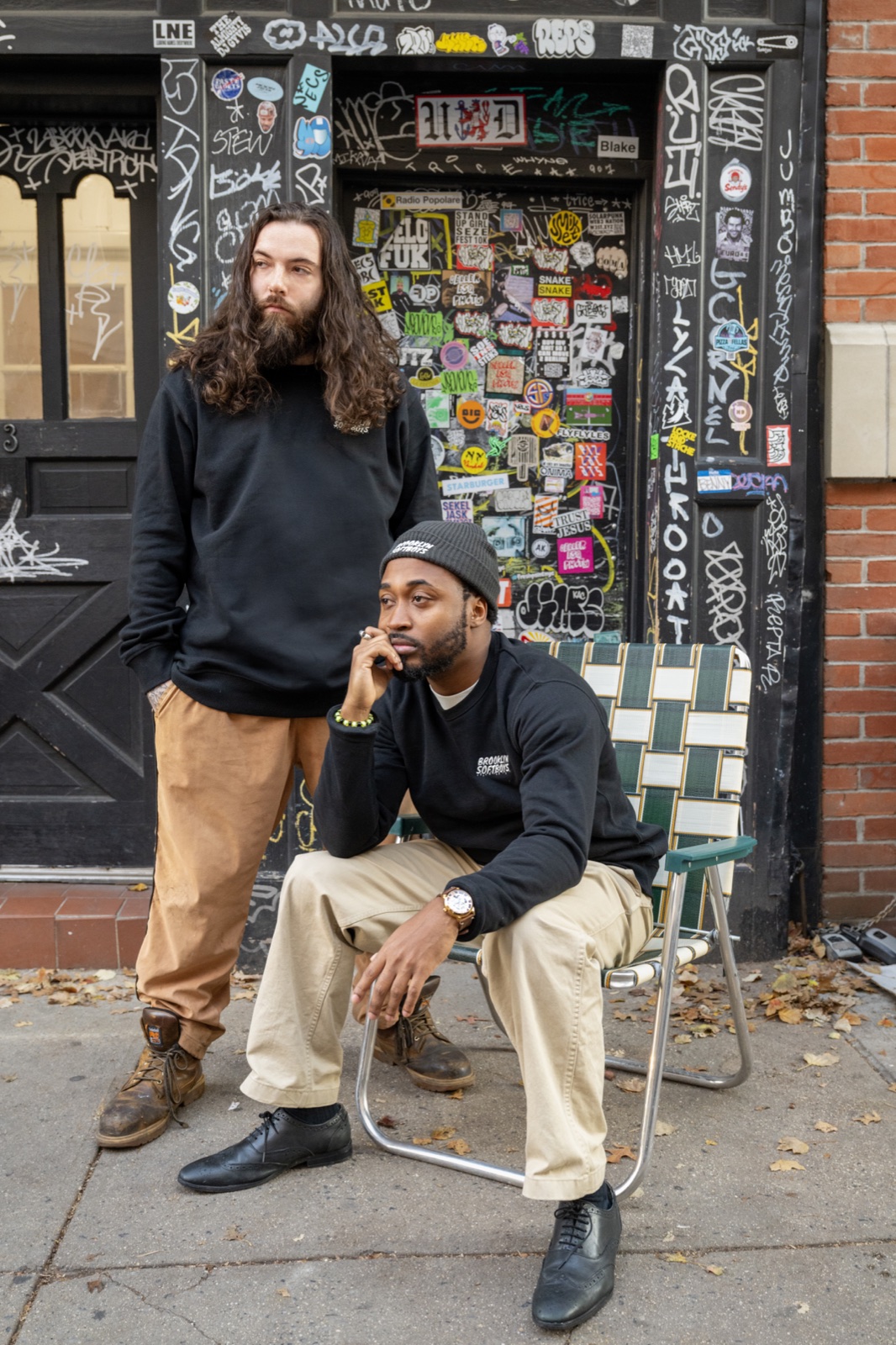 Brooklyn SoftBoys campaign — two models outside a sticker-covered NYC doorway.