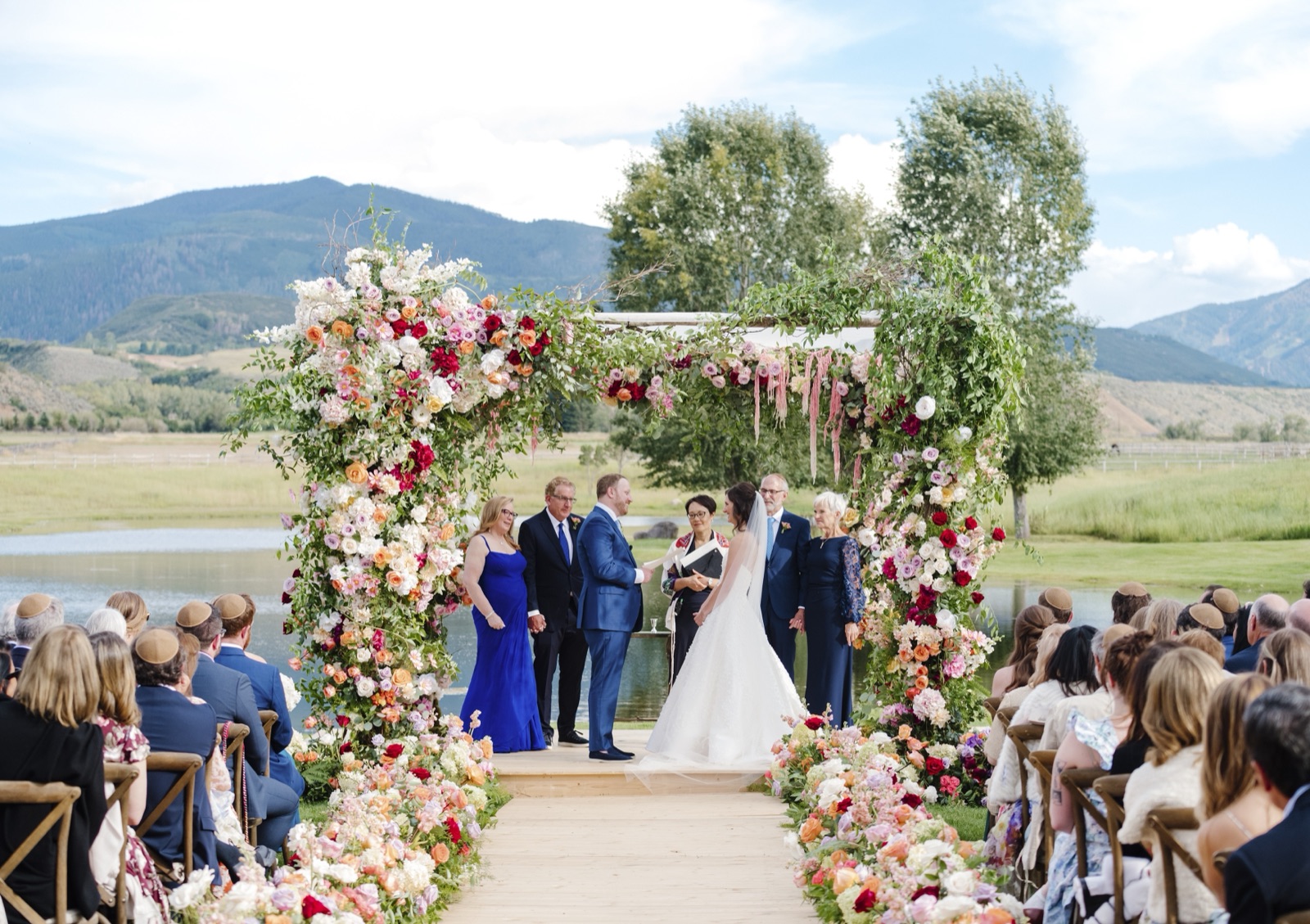 Mountain ceremony under a floral chuppah.